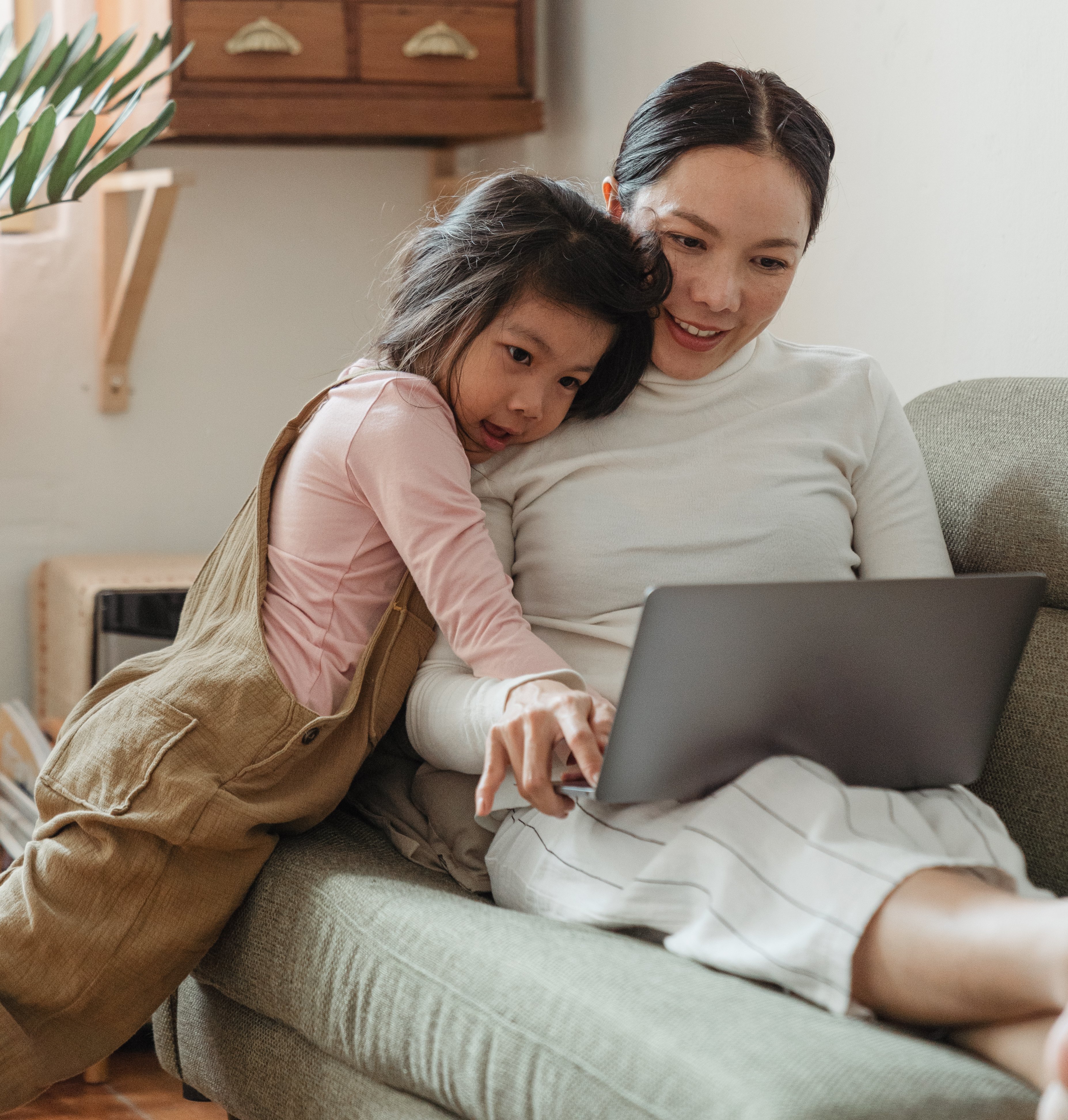 happy-mother-and-daughter-using-laptop-together-on-couch-4473902-1